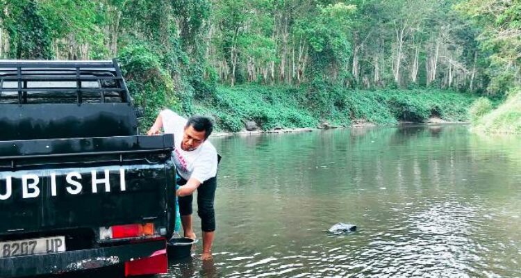 Warga mencuci mobil pikap di Kali Banten, Desa Rejomulyo, Jati Agung, Lampung Selatan.